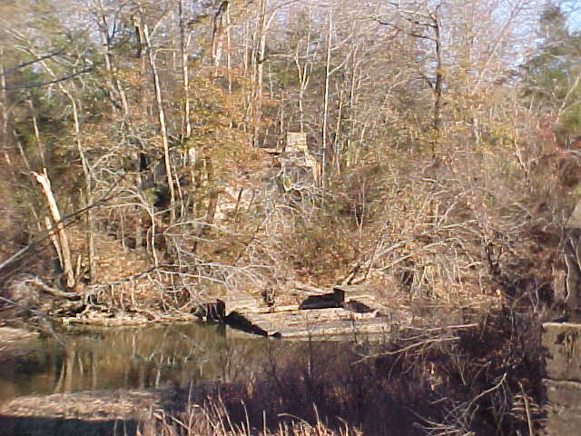 Pier in river, facing eastward, note abutment in woods behind pier